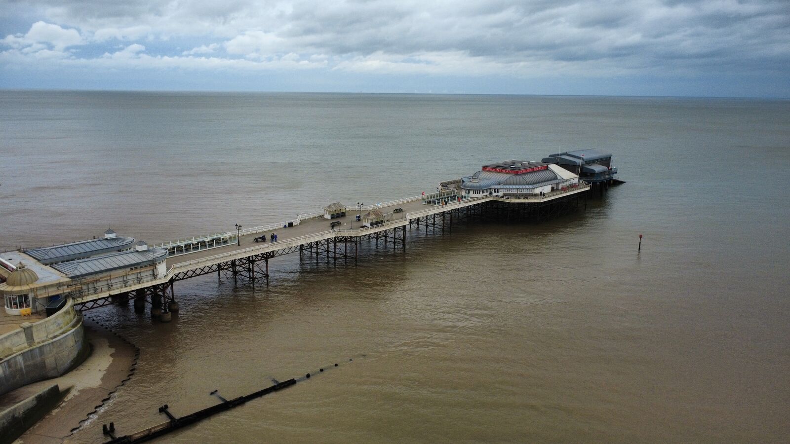 Aerial drone photograph of a seaside pier stretching into the sea